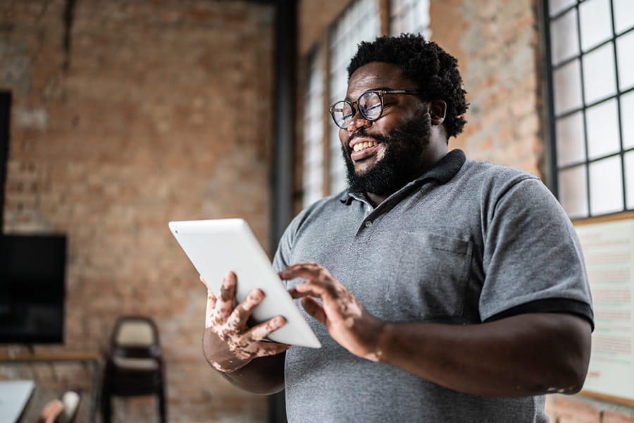 Person smiling while looking at a tablet