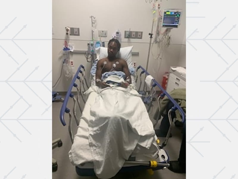 Evan Holyfield waits in a hospital bed