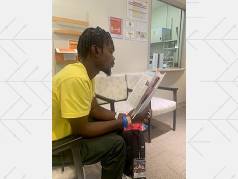 Evan Holyfield reading some documents in a waiting room